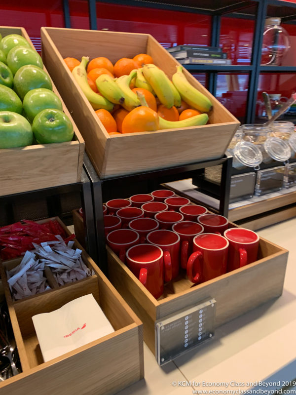 a shelf with fruit and mugs