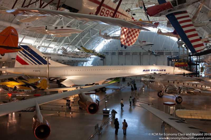 a group of people in a hangar with airplanes