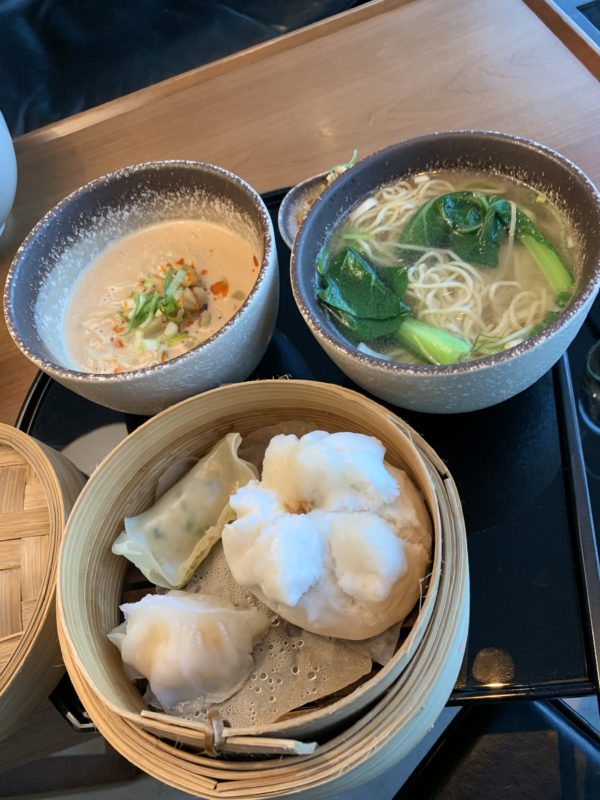 a group of bowls of soup and dumplings