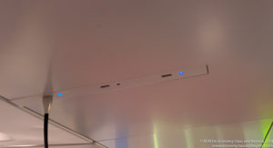 a white rectangular object with a blue light on the ceiling