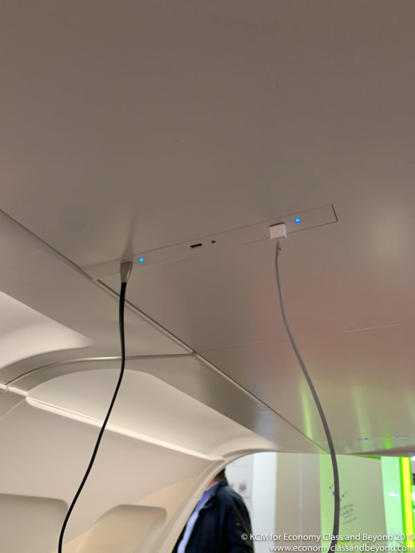a white ceiling with a power cord and a blue light
