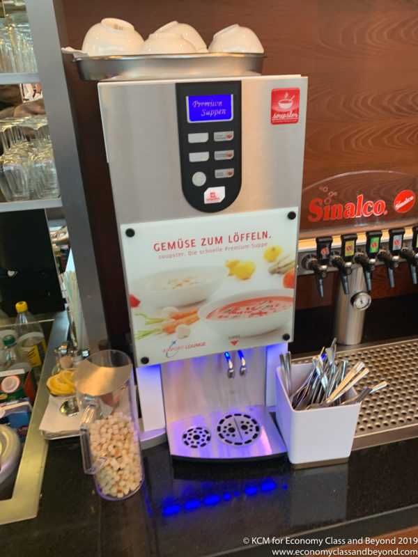 a machine with a screen and a container with utensils