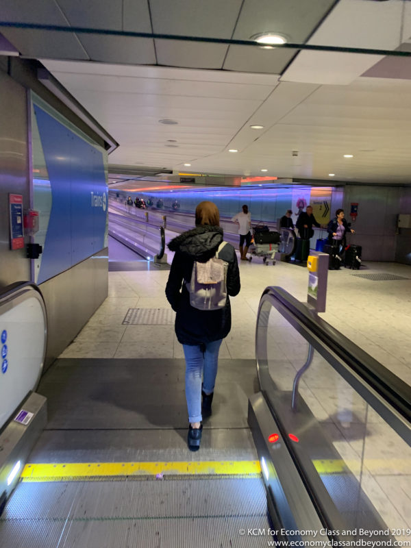 a woman walking down an escalator