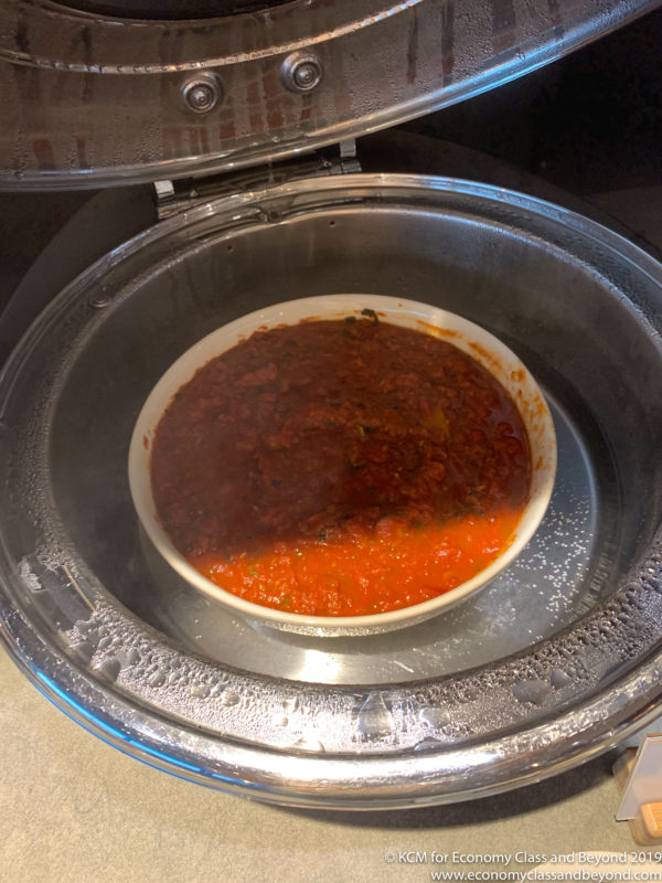 a bowl of red sauce in a metal container