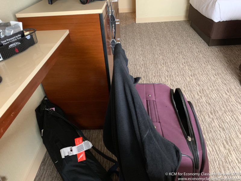 a purple suitcase next to a bed