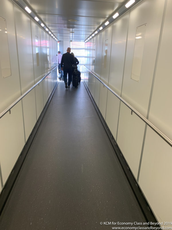 a man walking down a hallway with luggage