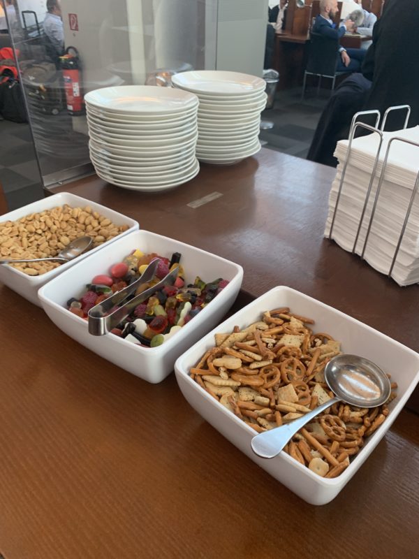 a group of bowls of snacks and a stack of plates