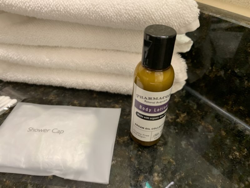 a bottle of body lotion next to a white towel