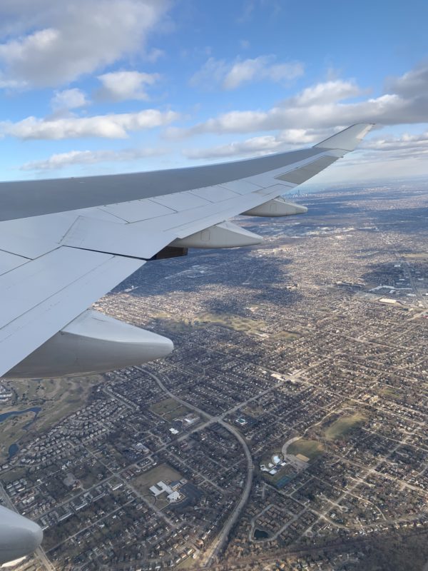 an airplane wing and city below