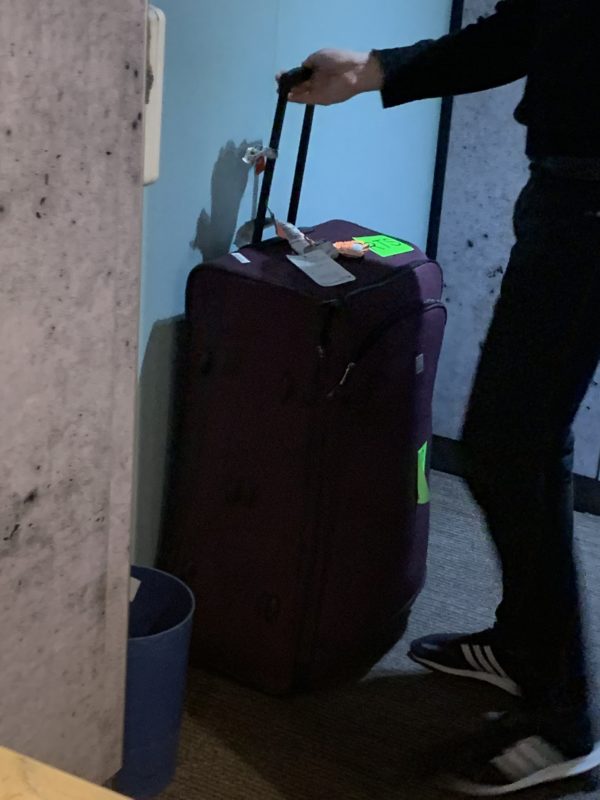 a person standing next to a suitcase