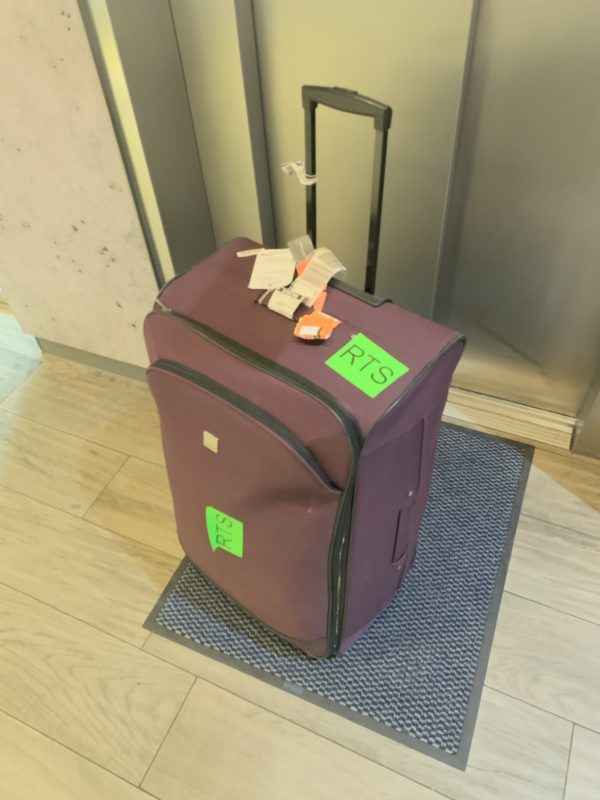 a purple suitcase with tags on it