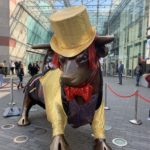 a statue of a bull wearing a hat and a bow tie