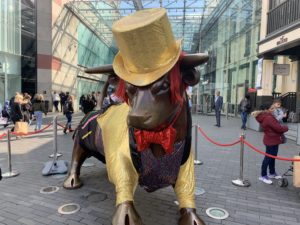 a statue of a bull wearing a hat and a bow tie