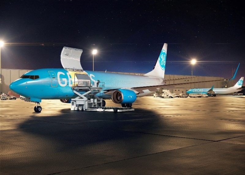 a blue airplane on a tarmac at night