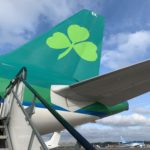 a green tail of an airplane with a clover on it