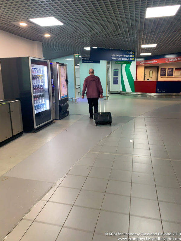 a man walking with a luggage bag in a airport