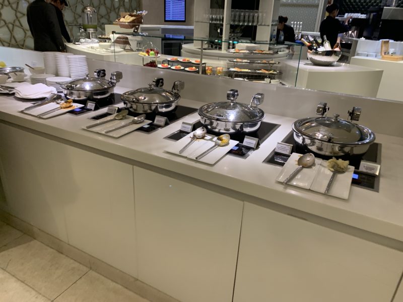 a buffet line with silver pots and silver spoons