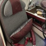 a seat with a pillow and a seat belt