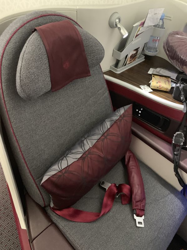 a seat with a seat belt and a pillow