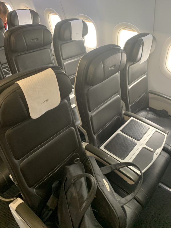 a row of black chairs on an airplane