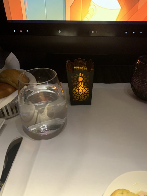 a glass of water and a candle on a table