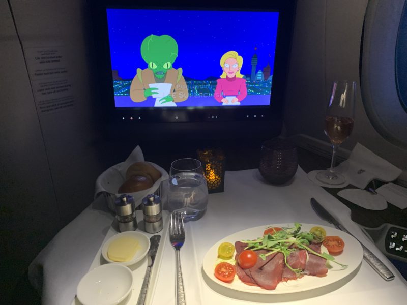 a table with a plate of food and a television