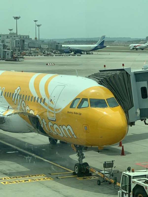 a yellow and white airplane at an airport
