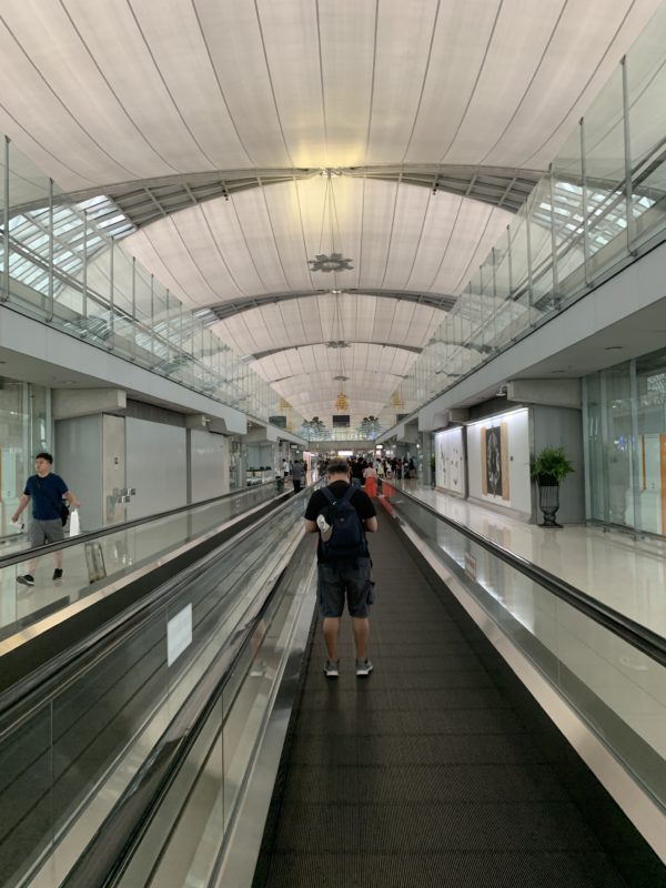 a man walking on a moving walkway in a airport