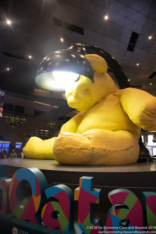 a large yellow stuffed bear with a lamp on top of it