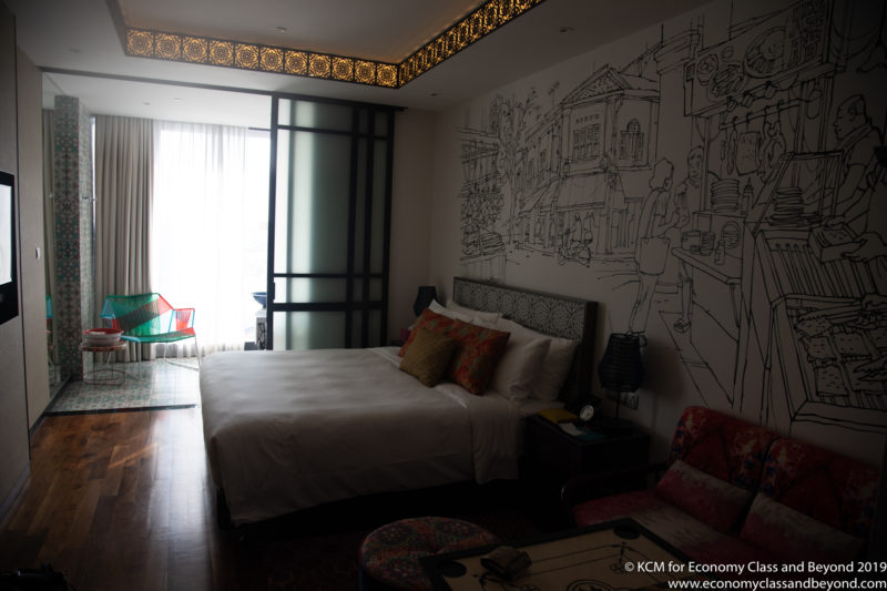 a room with a bed and a drawing on the wall
