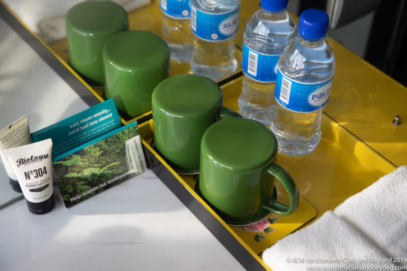 a tray with green cups and bottles of water