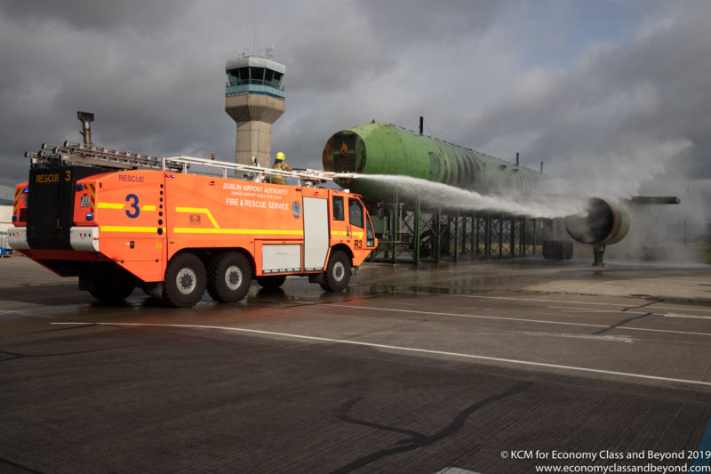 a fire truck spraying water on a large green object