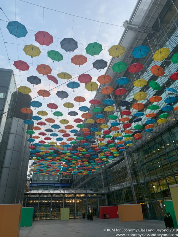 a multicolored umbrellas from the ceiling of a building