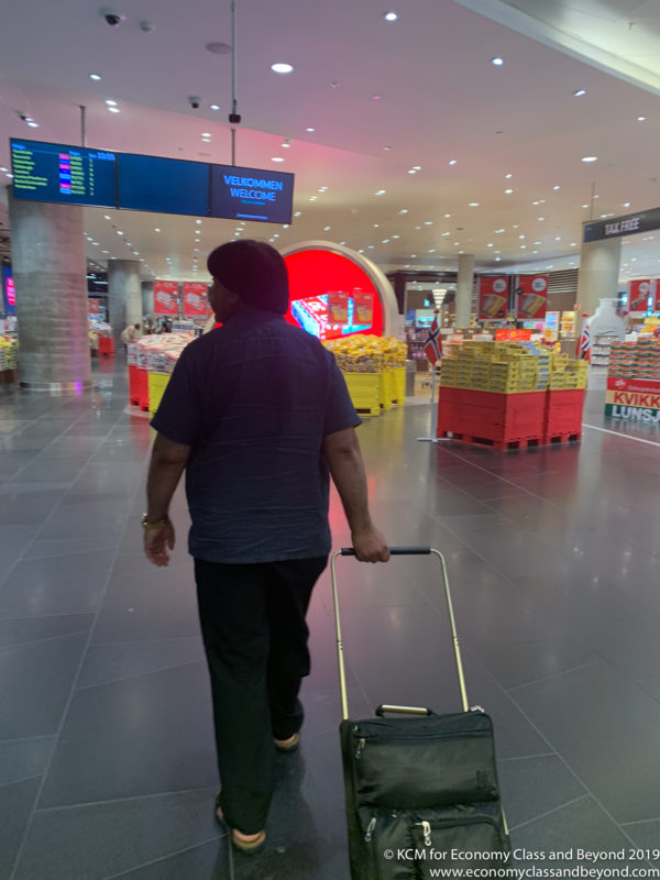 a man walking with a suitcase in a airport