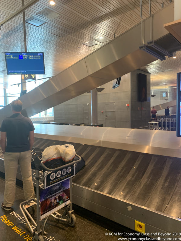 a man standing next to a luggage conveyor belt