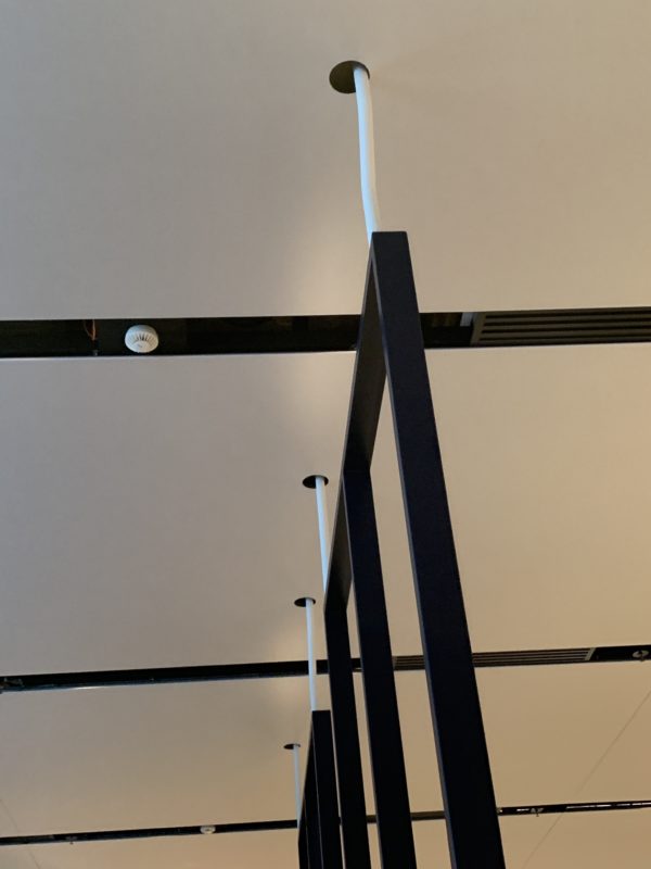 a white ceiling with black metal poles
