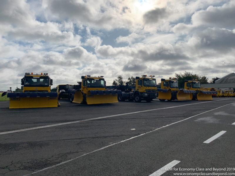 a group of yellow vehicles parked in a parking lot