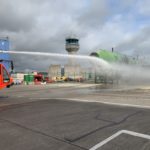a firetruck spraying water on a runway