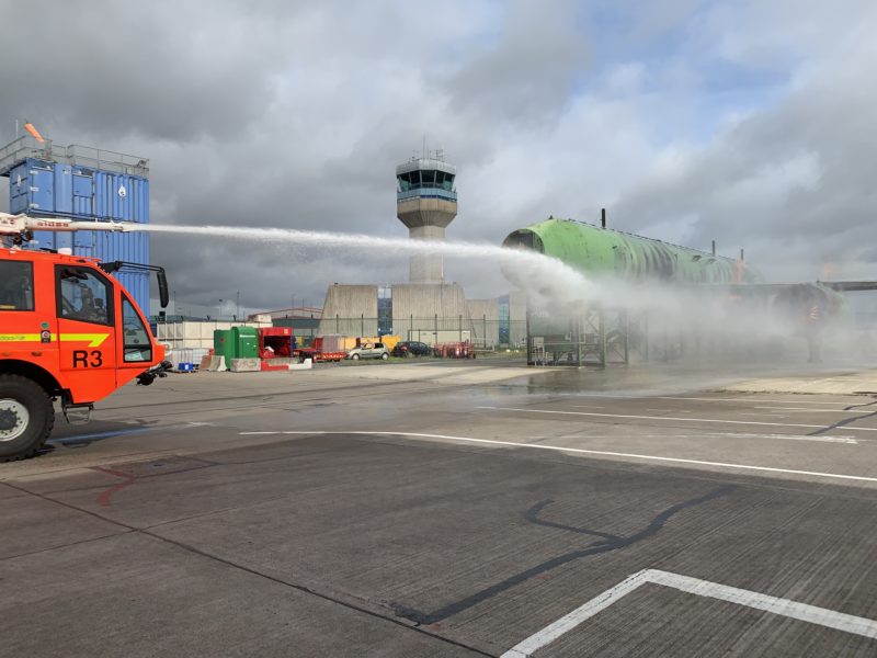 a firetruck spraying water on a runway