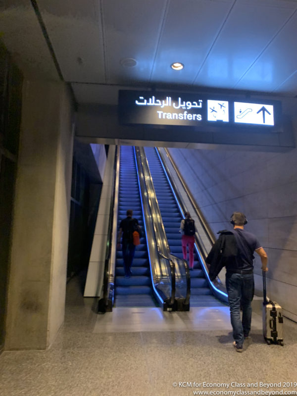 people with luggage on escalators