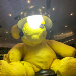 a yellow teddy bear with a black bowl on its head
