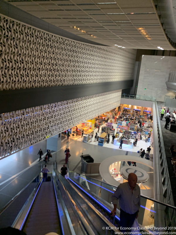 a group of people walking down escalators in a building