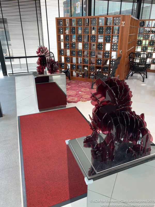a room with a red carpet and a glass statue