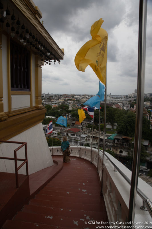 a woman standing on a balcony with flags