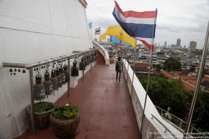 a woman walking on a balcony with flags