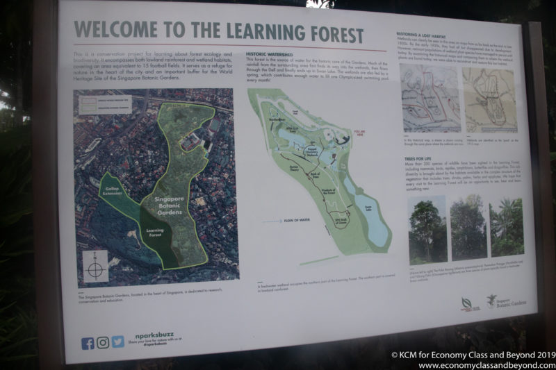 a sign with a map and a map of a forest
