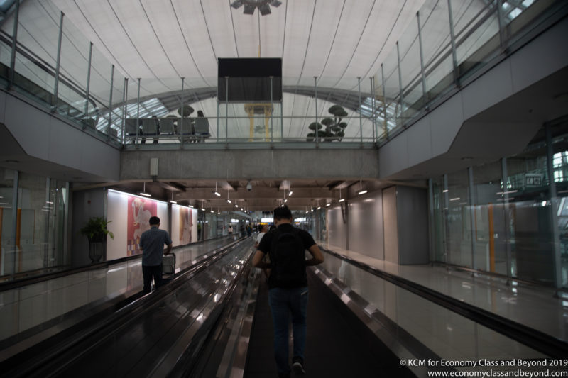a man walking down a walkway in a airport
