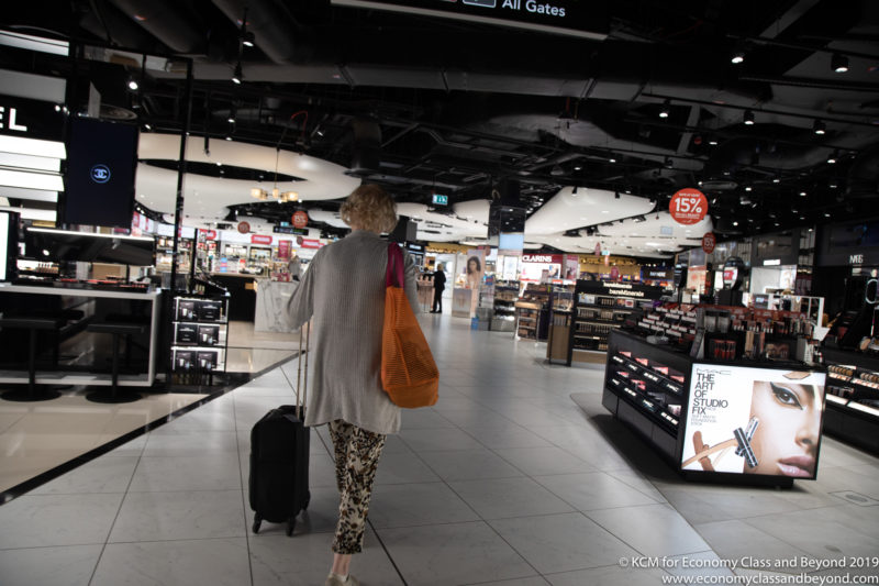 a woman walking with luggage in a store