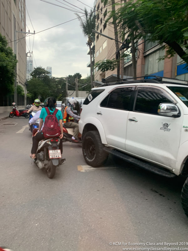 a group of people on a motorcycle and a white suv