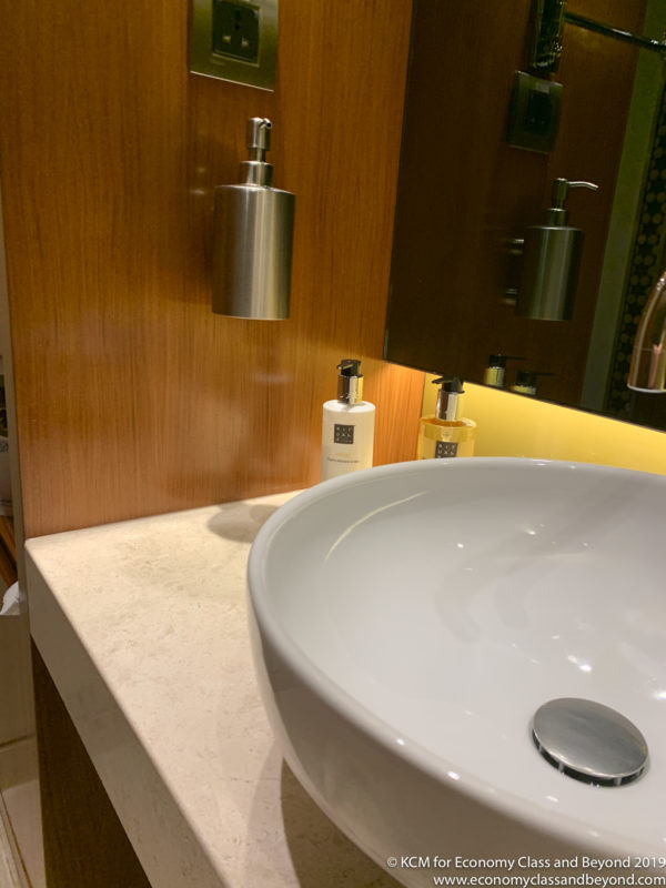 a sink and soap dispenser in a bathroom